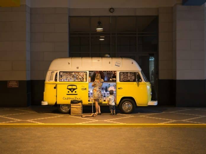 Photo by Dmitry Nucky Thompson woman and child standing in front of yellow bus in car park