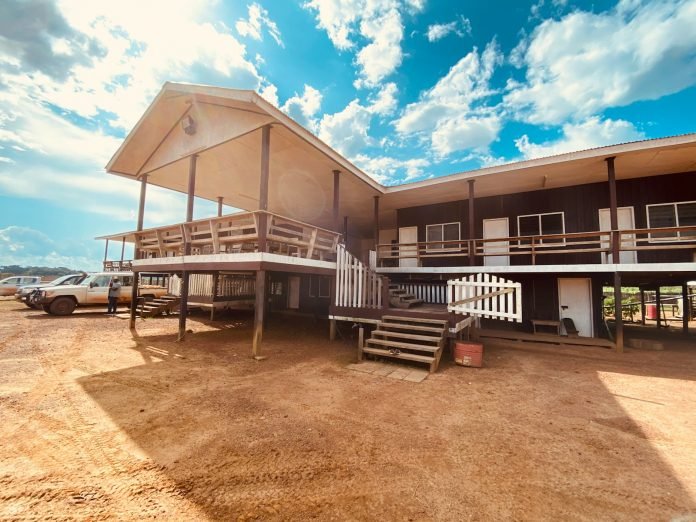 Photo by Christ Eliezer BOUBOUE white wooden house near body of water during daytime