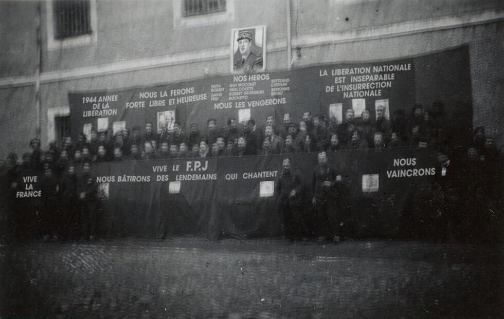 Cette tribune vantant la force et l'unité de la Résistance sous le portrait du général De Gaulle regroupe des responsables du Collectif des détenus résistants de la centrale d'Eysses, organisateurs d'une "fête de la jeunesse" dans la prison, le 16 janvier 1944.