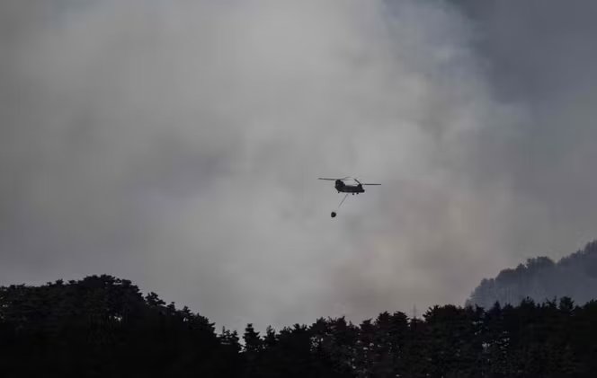 Un hélicoptère effectuant des largages d’eau près de la ville d’Otsuchi, dans la préfecture d’Iwate, le 25 avril 2026.