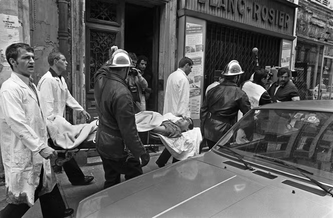 Des pompiers et ambulanciers évacuent un blessé de l’attentat rue des Rosiers, à Paris, le 9 aout 1982.