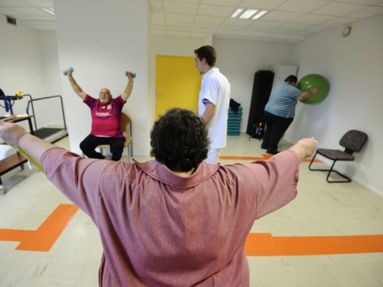 Un physiothérapeute aide des patients obèses avec des exercices au CHU d
