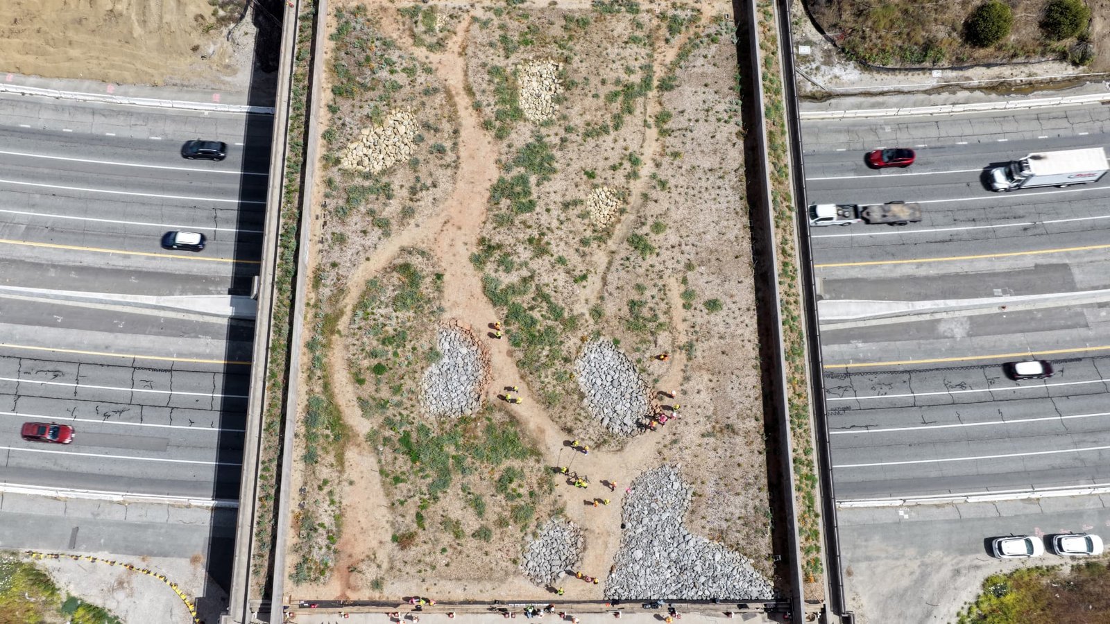 Vue aérienne de journalistes et de partenaires du projet visitant le chantier du passage faunique Wallis Annenberg au-dessus de l'autoroute 101, le Jour de la Terre, le 22 avril 2026 à Agoura Hills, en Californie. 