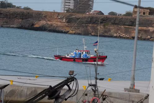 Des agents de santé en tenue de protection évacuent des patients du navire de croisière MV « Hondius », dans un port de Praia, au Cap-Vert, le 6 mai 2026.