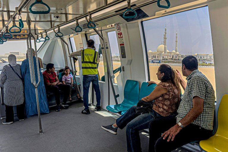 Des passagers à bord du monorail récemment inauguré près de la grande mosquée al-Fattah al-Alim  dans la nouvelle capitale administrative, à l'est du Caire, le 22 mai 2026, en Egypte (AFP - Khaled DESOUKI)