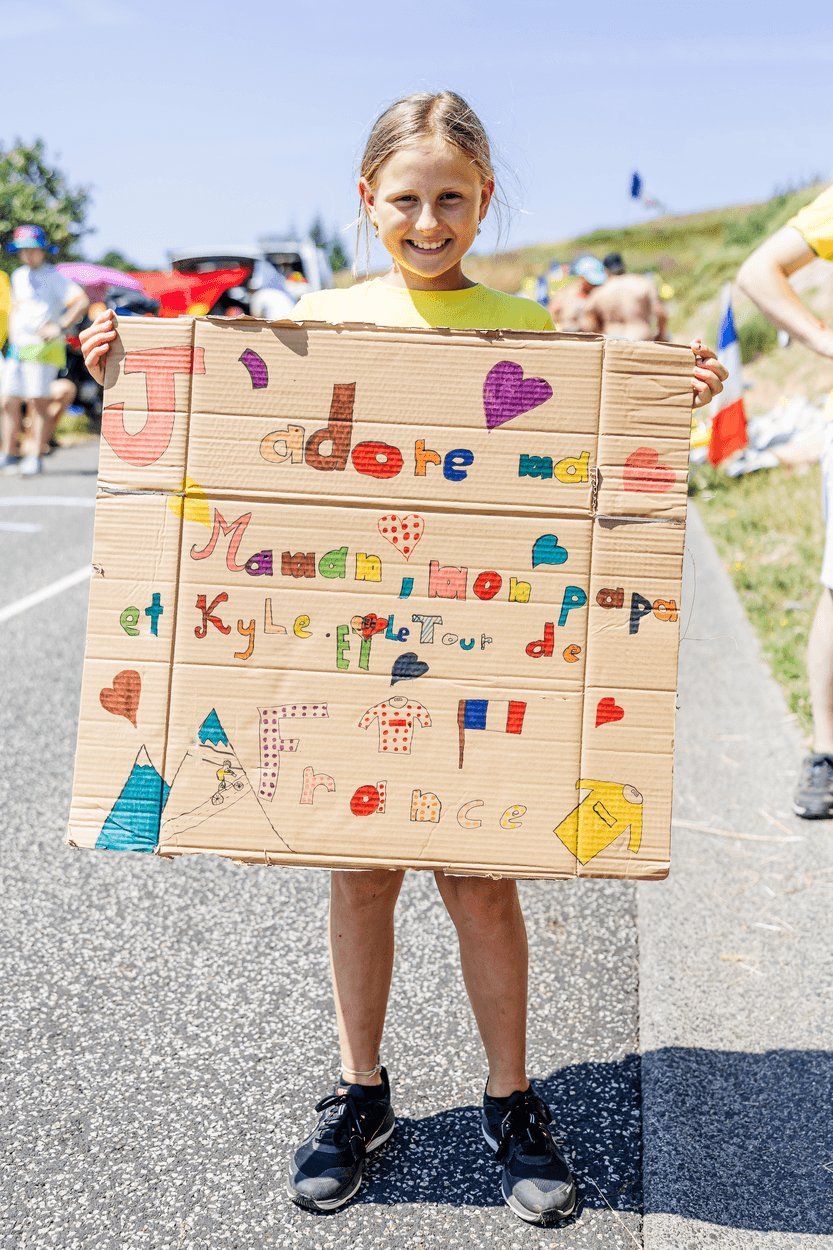 Une jeune fille avec la pancarte qu’elle a préparée pour le passage du Tour de France.