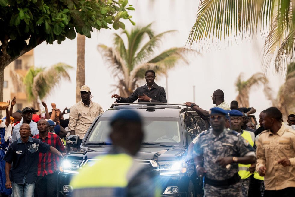 Bassirou Diomaye Faye salue ses partisans à l'issue d'une cérémonie de lancement de Kiiraay, son nouveau parti, dans le quartier des Almadies à Dakar, le 25 juillet 2026.