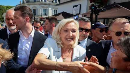 Marine Le Pen du Rassemblement national à son arrivée aux côtés de Jordan Bardella (à gauche) à La Flèche (Sarthe), le 8 juillet 2026, (FRED TANNEAU / AFP)