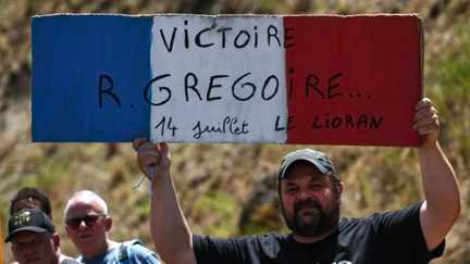 Un spectateur encourage le Français Romain Grégoire pour une victoire lors du 14 juillet dans la 10e étape entre Aurillac et Le Lioran dans le Cantal. (ANNE-CHRISTINE POUJOULAT / AFP)