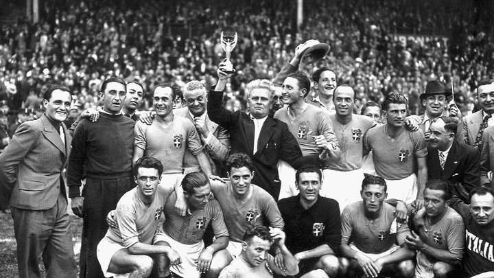 Vittorio Pozzo porte le trophée Jules Rimet de la Coupe du monde, entouré de ses joueurs, après la victoire en finale de l'Italie contre la Hongrie, le 19 juin 1938 à Colombes. (STAFF / AFP)