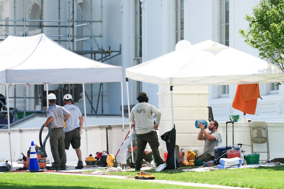 Un employé du Service des parcs nationaux se rafraîchit en travaillant près du portique nord de la Maison-Blanche, en pleine vague de chaleur, le 30 juin 2026 à Washington.