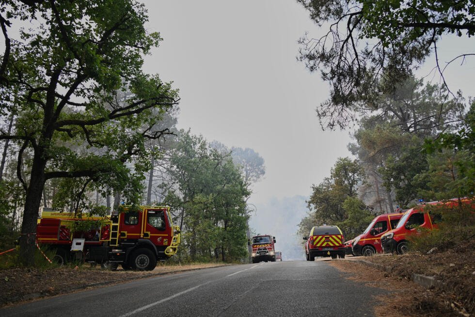Des camions de pompiers sont stationnés près du lieu d'un incendie de forêt dans la région de la forêt historique de Fontainebleau, à environ 60 km au sud de Paris, le lundi 13 juillet 2026.