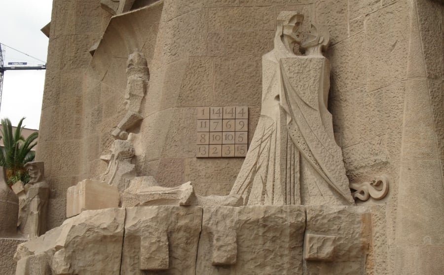 Statue du baiser de Judas et carré magique sur la façade de la Passion de la Sagrada Família, en mai 2008. | Mathieu Brossais / CC BY 4.0 / Wikimedia Commons